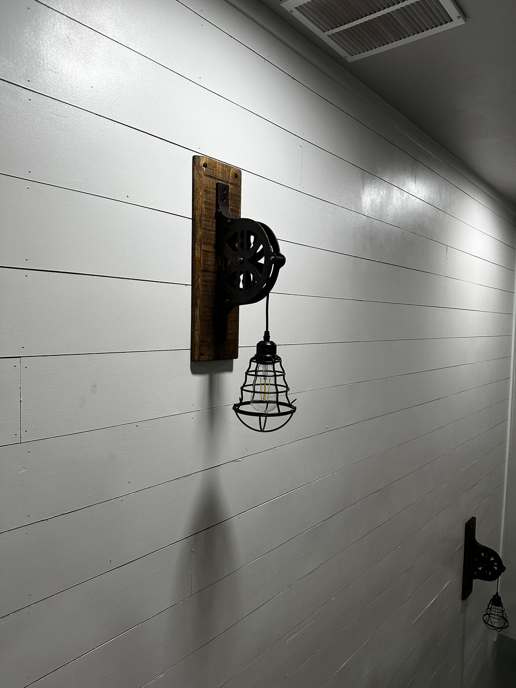 Upcycled antique pulley wall sconce